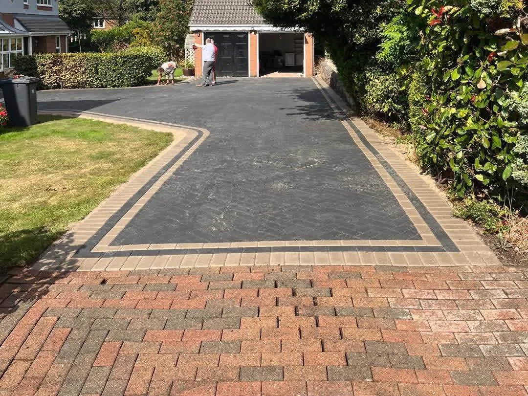 Completed dark tarmac driveway with brick edging